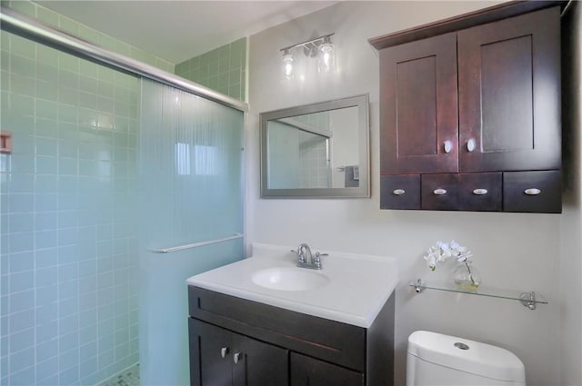 bathroom featuring vanity, toilet, and tiled shower