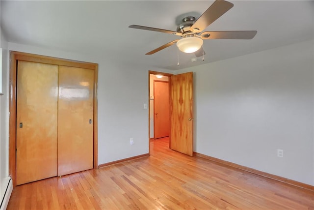 unfurnished bedroom with ceiling fan, baseboards, a closet, a baseboard heating unit, and light wood finished floors