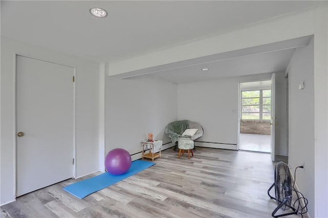 exercise room with recessed lighting, a baseboard radiator, and wood finished floors