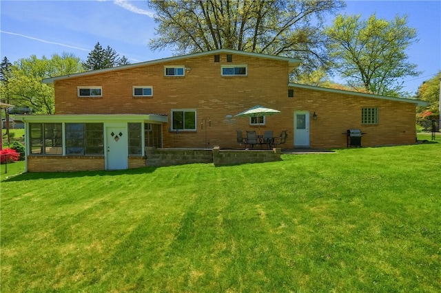 back of house with a sunroom, a yard, and a patio area