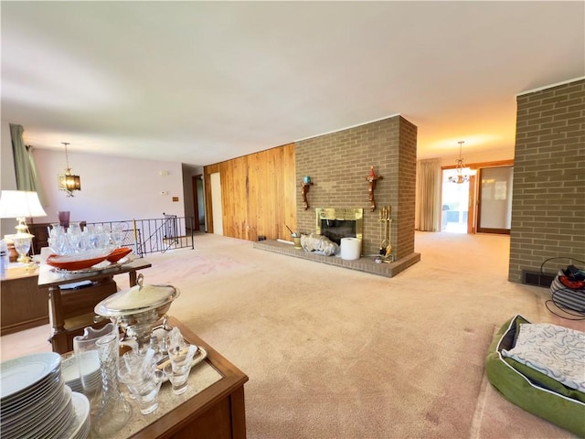 living room featuring carpet flooring, a brick fireplace, a notable chandelier, and wood walls