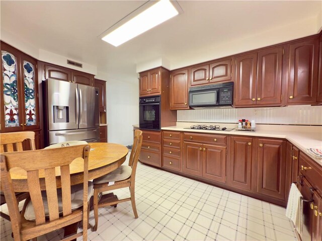 kitchen featuring light countertops, visible vents, and black appliances
