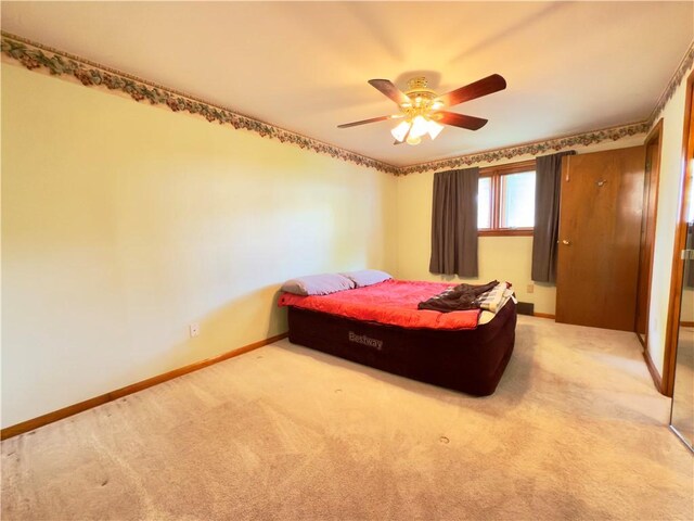 carpeted bedroom featuring baseboards and ceiling fan