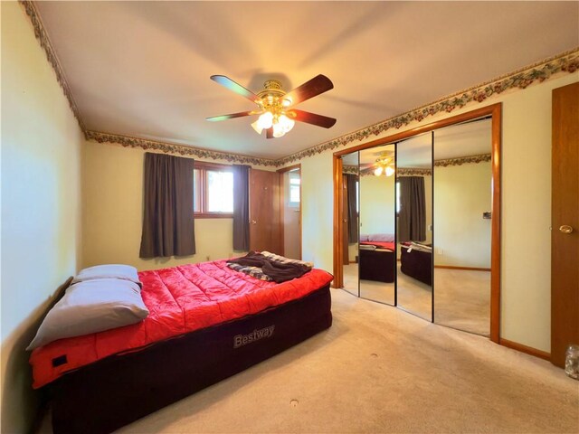 bedroom featuring a closet, carpet flooring, baseboards, and a ceiling fan