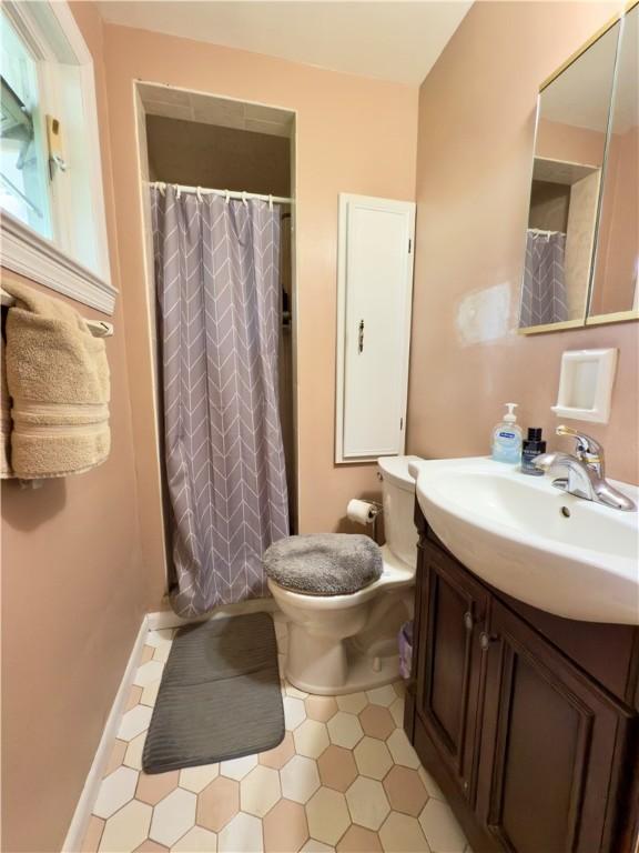bathroom featuring toilet, tile patterned floors, curtained shower, and vanity