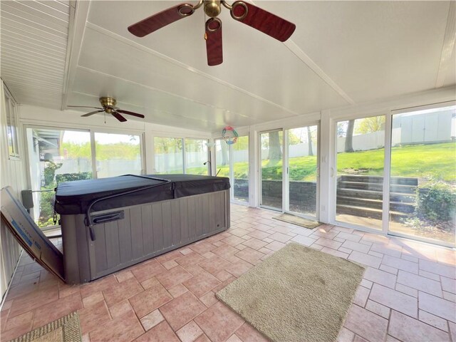 sunroom / solarium featuring a ceiling fan, a hot tub, and a healthy amount of sunlight