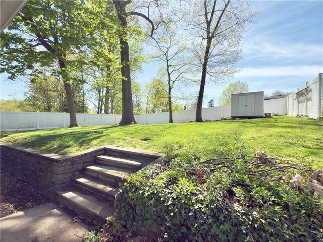 view of yard featuring a storage shed, an outdoor structure, and a fenced backyard