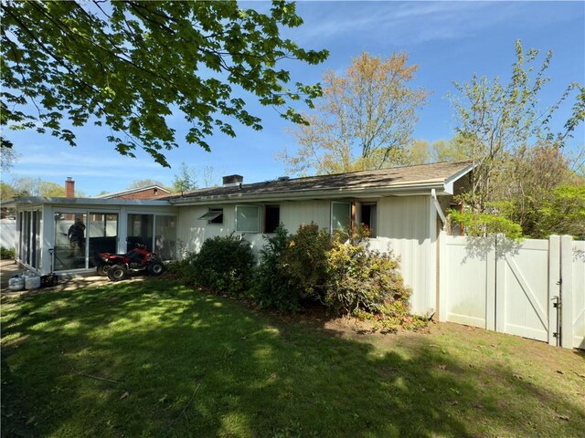 back of house with a sunroom, fence, and a yard