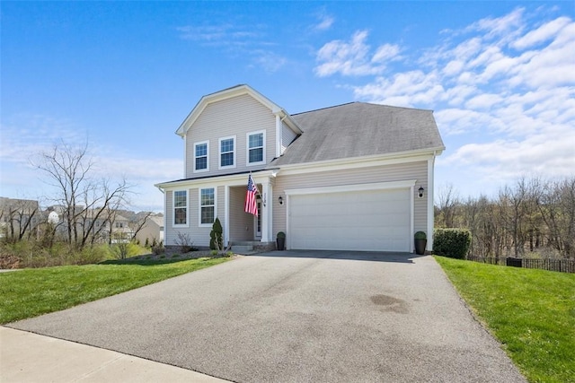 traditional home with a garage, a front lawn, and aphalt driveway