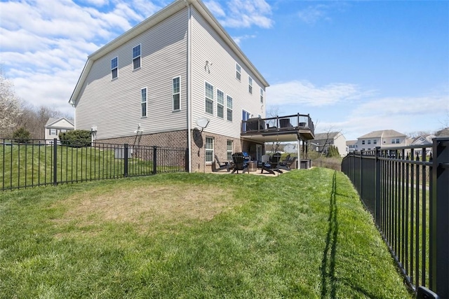 rear view of property with a fenced backyard, a patio, a yard, and brick siding