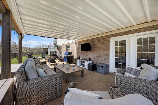 view of patio / terrace featuring a wooden deck, a fenced backyard, area for grilling, an outdoor living space, and exterior kitchen