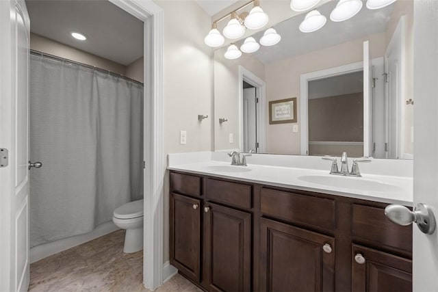 bathroom featuring double vanity, toilet, a shower with curtain, and a sink