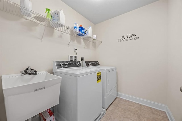 laundry room with laundry area, a sink, baseboards, and washing machine and dryer