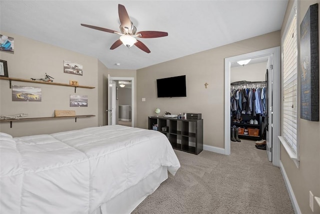 carpeted bedroom with a ceiling fan, baseboards, a spacious closet, and a closet