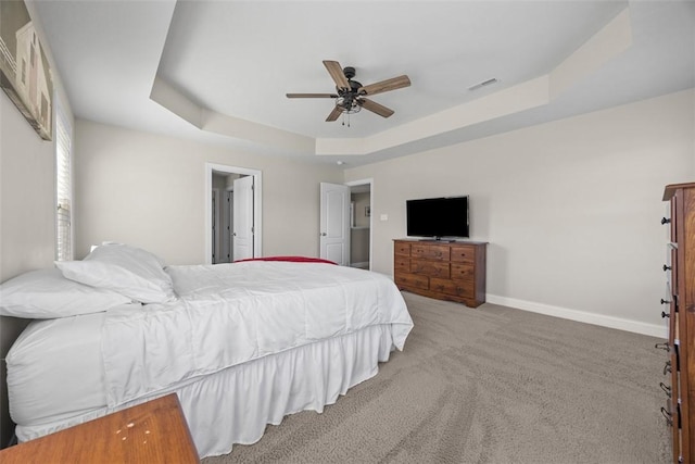 bedroom with ceiling fan, a raised ceiling, carpet, baseboards, and visible vents