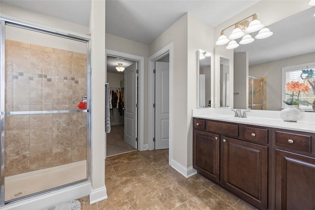 full bathroom featuring vanity, baseboards, a shower stall, and a spacious closet