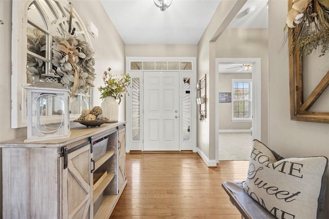 entryway with light wood-style floors, baseboards, and ceiling fan