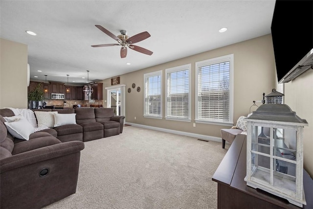 living area featuring recessed lighting, ceiling fan, visible vents, and light colored carpet