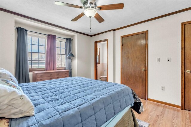 bedroom featuring crown molding, ceiling fan, light wood-style floors, baseboards, and ensuite bathroom