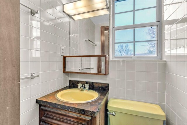 bathroom with vanity, tasteful backsplash, toilet, and tile walls
