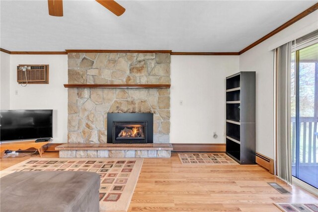 living room featuring ceiling fan, baseboard heating, wood finished floors, visible vents, and ornamental molding