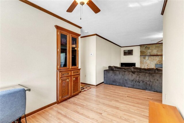 unfurnished living room featuring baseboards, a ceiling fan, light wood finished floors, and ornamental molding