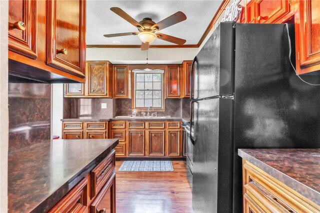 kitchen featuring freestanding refrigerator, ceiling fan, crown molding, and wood finished floors