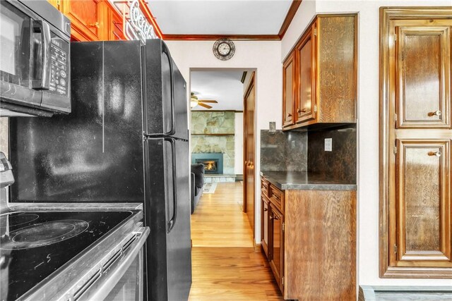 kitchen featuring a ceiling fan, crown molding, brown cabinets, stainless steel range with electric cooktop, and light wood-style floors
