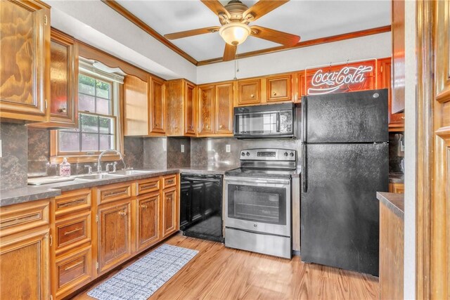 kitchen with a ceiling fan, brown cabinets, a sink, light wood-style flooring, and black appliances