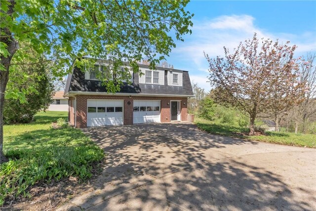 view of front of property featuring brick siding, a garage, and driveway