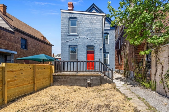 7314 Monticello St, Homewood-Brushton, PA 15208 - back of house featuring fence, a chimney, and brick siding