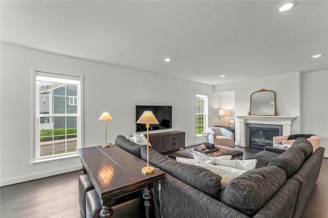 living area featuring baseboards, recessed lighting, wood finished floors, and a wealth of natural light