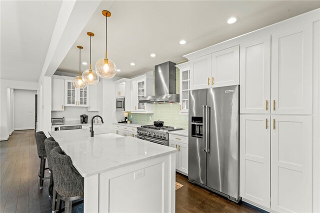 kitchen featuring a sink, wall chimney exhaust hood, dark wood finished floors, and high quality appliances
