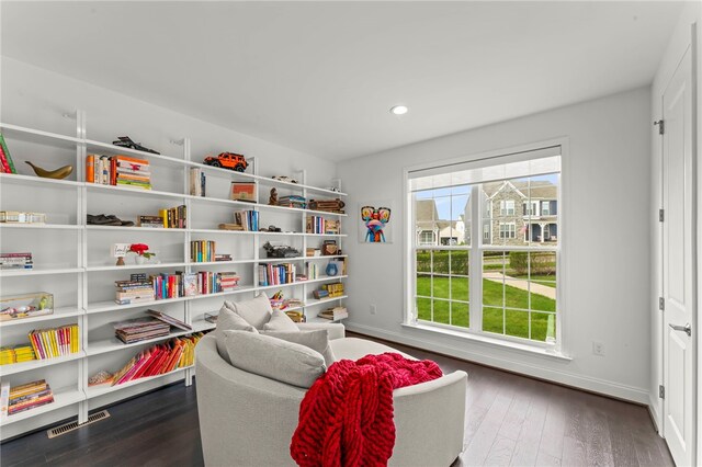living area with recessed lighting, baseboards, visible vents, and dark wood finished floors