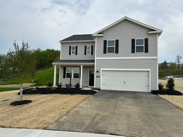 traditional home with an attached garage, aphalt driveway, and a porch