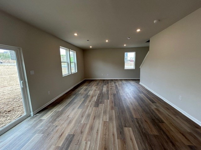 unfurnished living room featuring baseboards, plenty of natural light, recessed lighting, and wood finished floors