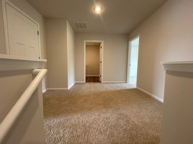 carpeted empty room featuring baseboards and visible vents
