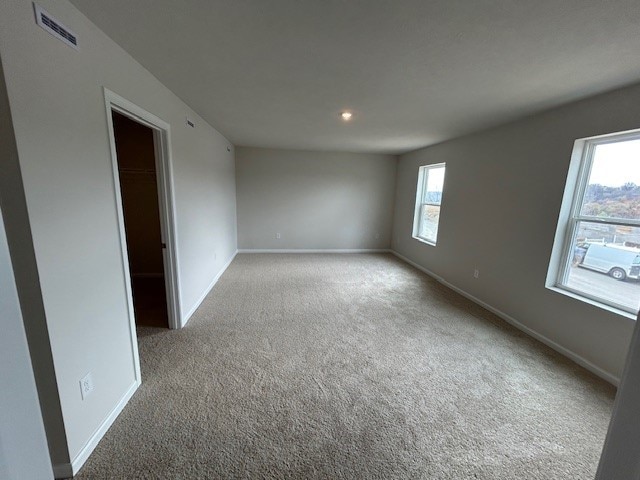 carpeted spare room featuring baseboards, recessed lighting, and visible vents