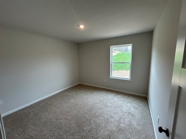 carpeted spare room featuring baseboards and recessed lighting