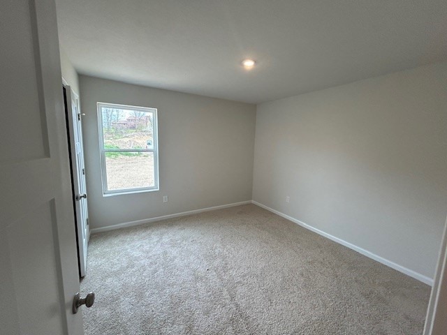 spare room with baseboards and carpet flooring
