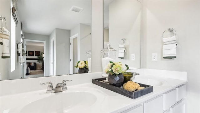 full bathroom featuring double vanity, visible vents, and a sink