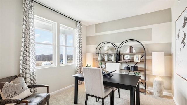 carpeted dining space with baseboards
