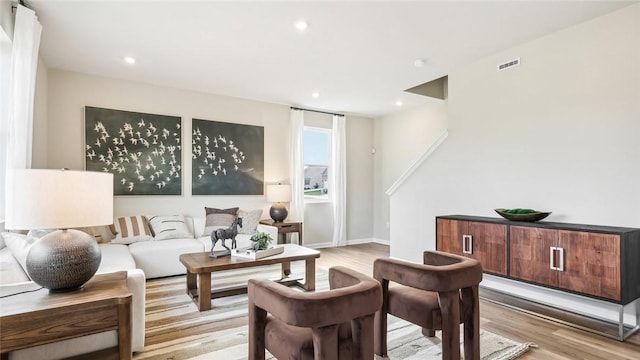 living area featuring recessed lighting, baseboards, light wood finished floors, and visible vents