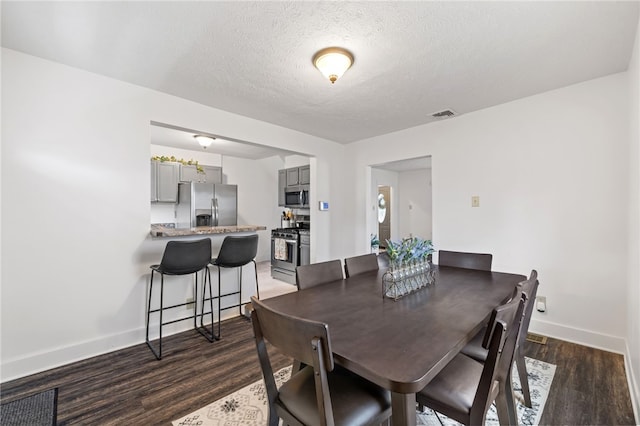 1629 Davidson St, Aliquippa, PA 15001 - dining space featuring visible vents, a textured ceiling, baseboards, and wood finished floors