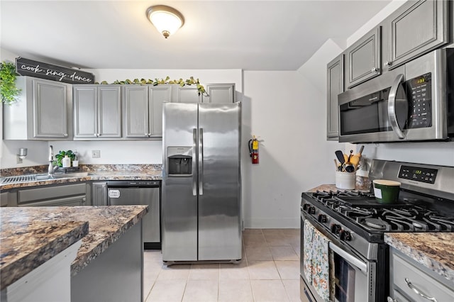 1629 Davidson St, Aliquippa, PA 15001 - kitchen with appliances with stainless steel finishes, a sink, baseboards, light tile patterned floors, and gray cabinetry