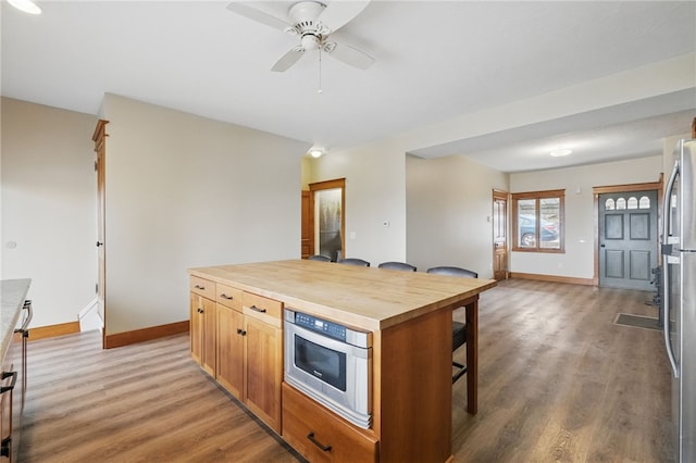 2715 Mission St, South Side, PA 15203 - kitchen featuring baseboards, a kitchen breakfast bar, light wood-type flooring, and butcher block countertops