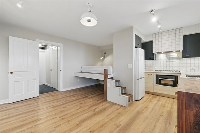 2715 Mission St, South Side, PA 15203 - kitchen featuring freestanding refrigerator, black oven, light wood-type flooring, tasteful backsplash, and rail lighting
