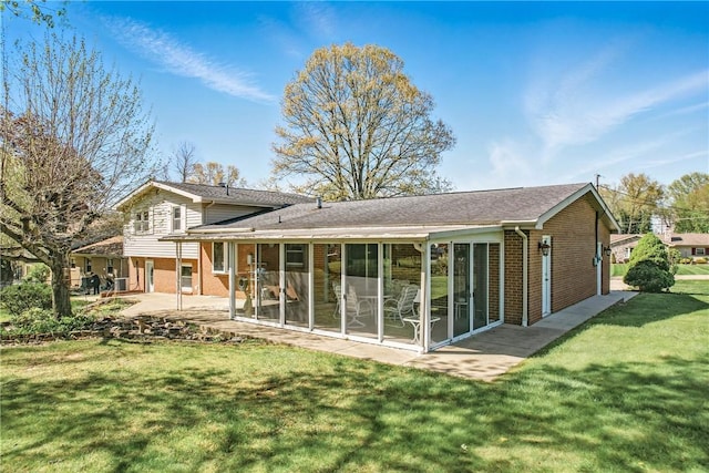 3640 Ridgewood Dr, Hermitage, PA 16148 - rear view of house with a patio, roof with shingles, brick siding, a sunroom, and a lawn