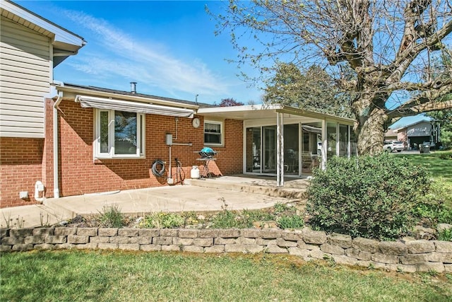 3640 Ridgewood Dr, Hermitage, PA 16148 - back of house featuring brick siding, a patio area, a lawn, and a sunroom