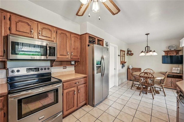 3640 Ridgewood Dr, Hermitage, PA 16148 - kitchen with light tile patterned floors, a ceiling fan, stainless steel appliances, and brown cabinets